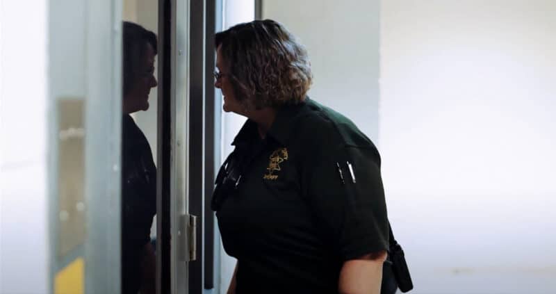 Corrections officer looking out through a interior window