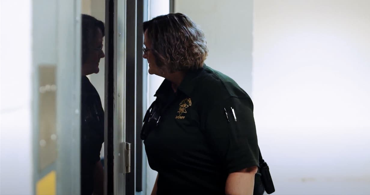 Corrections officer looking out through a interior window