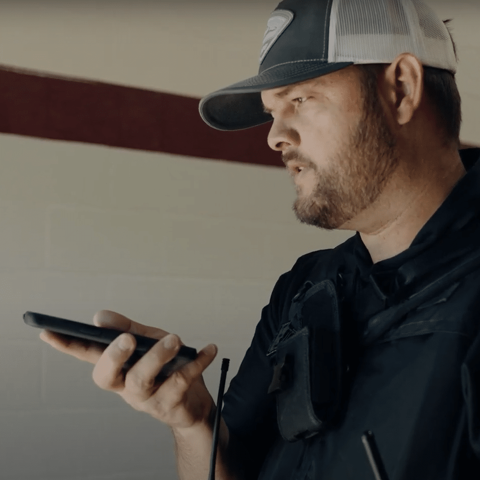 School resource officer talking on speakerphone with a mobile phone